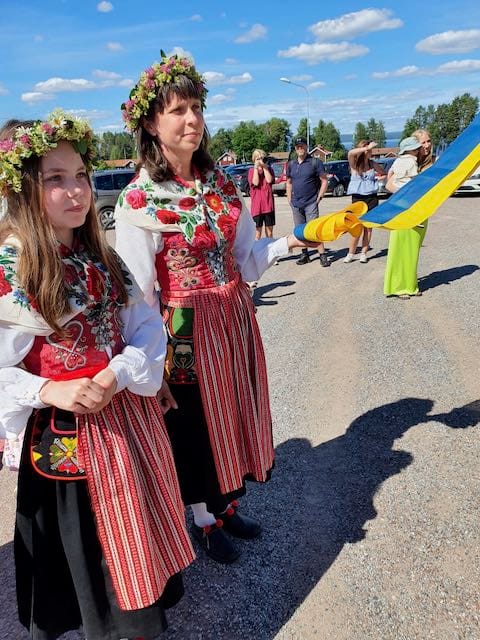 Kvinna och flicka i leksandsdräkt på midsommar, blå himmel